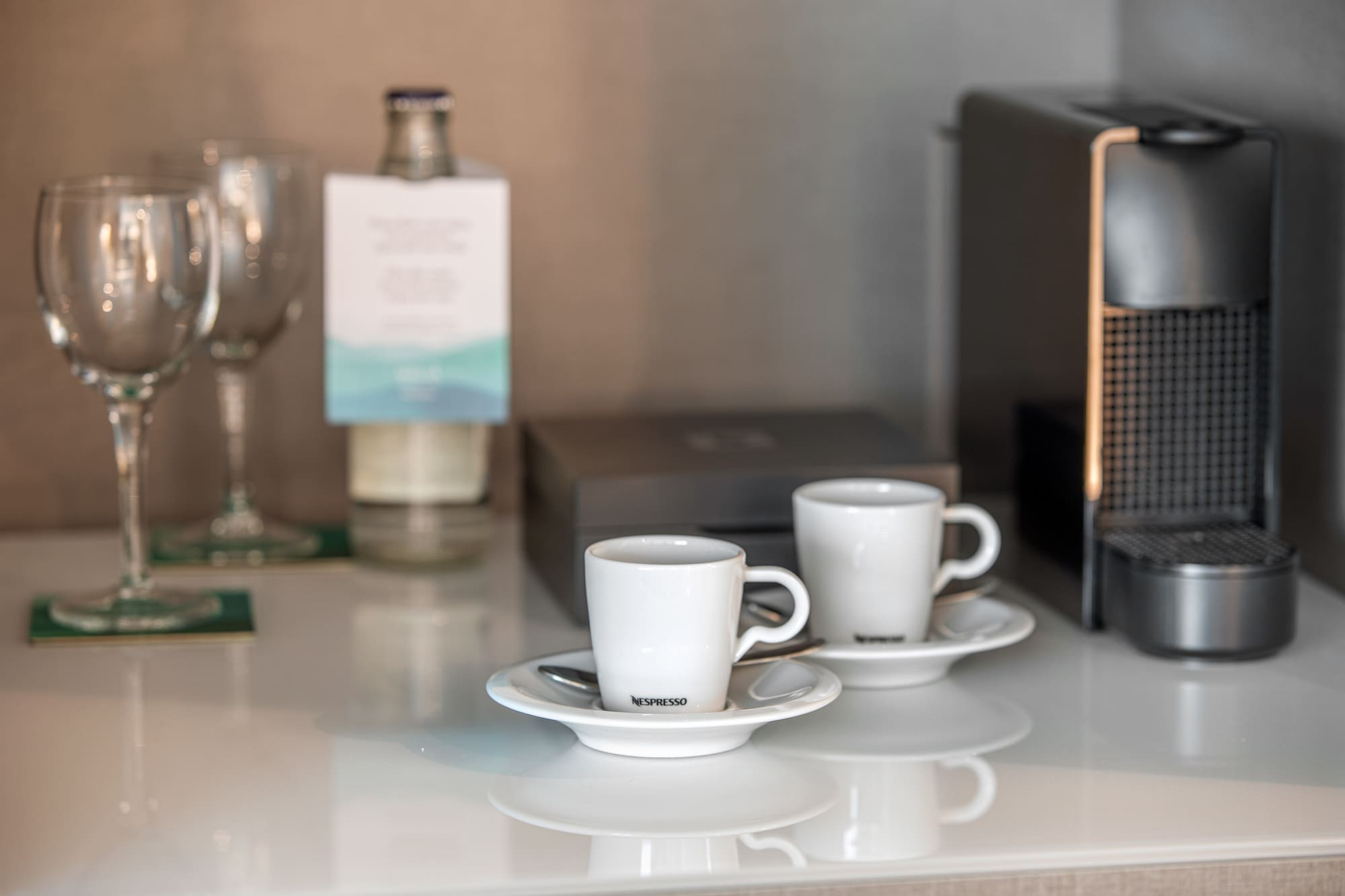 a couple of white cups on saucers on a table