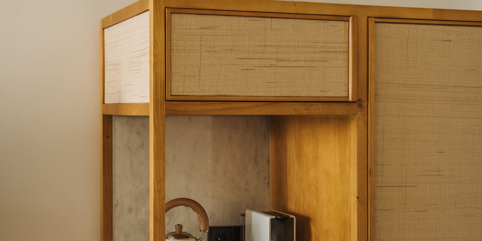 a cabinet with a tea kettle and coffee cups on top