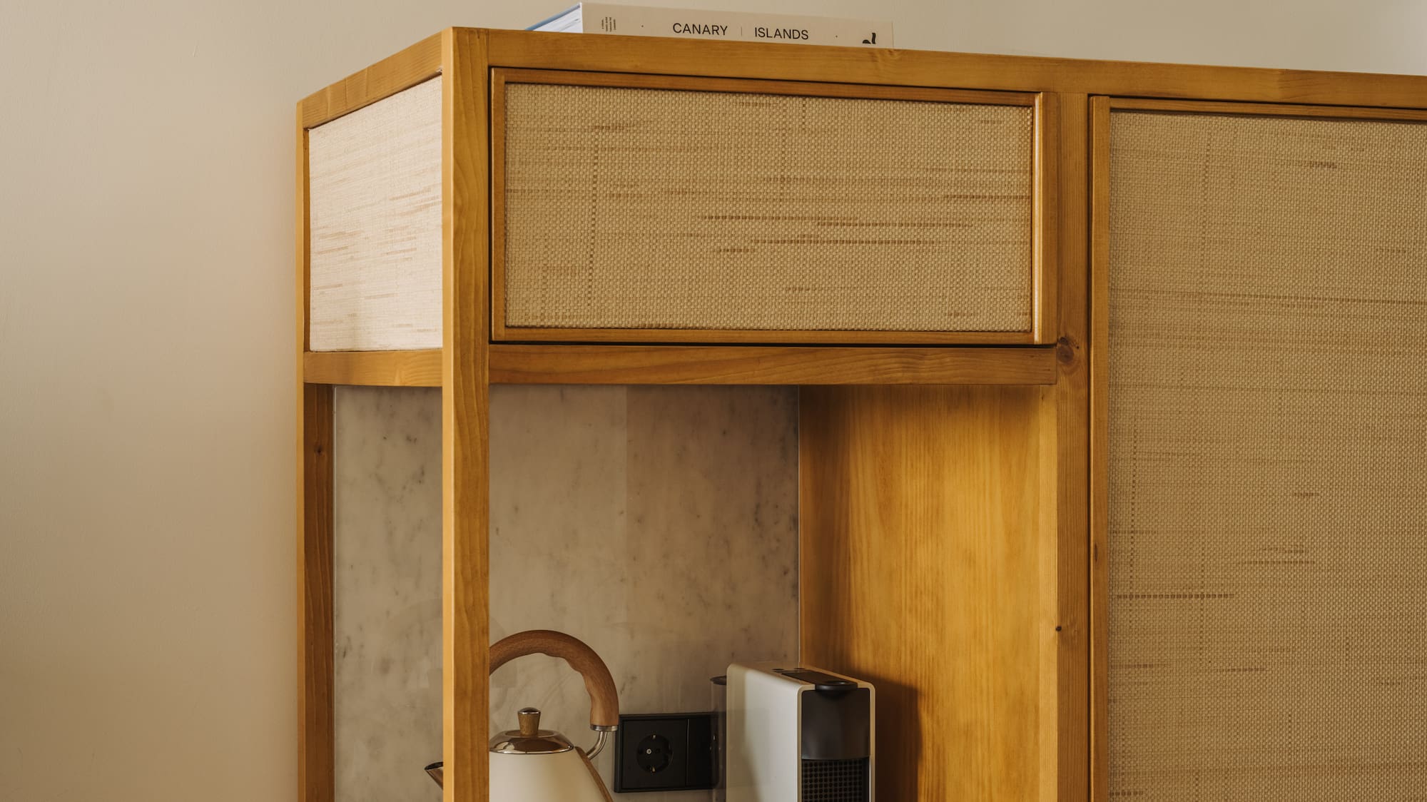 a cabinet with a tea kettle and coffee cups on top