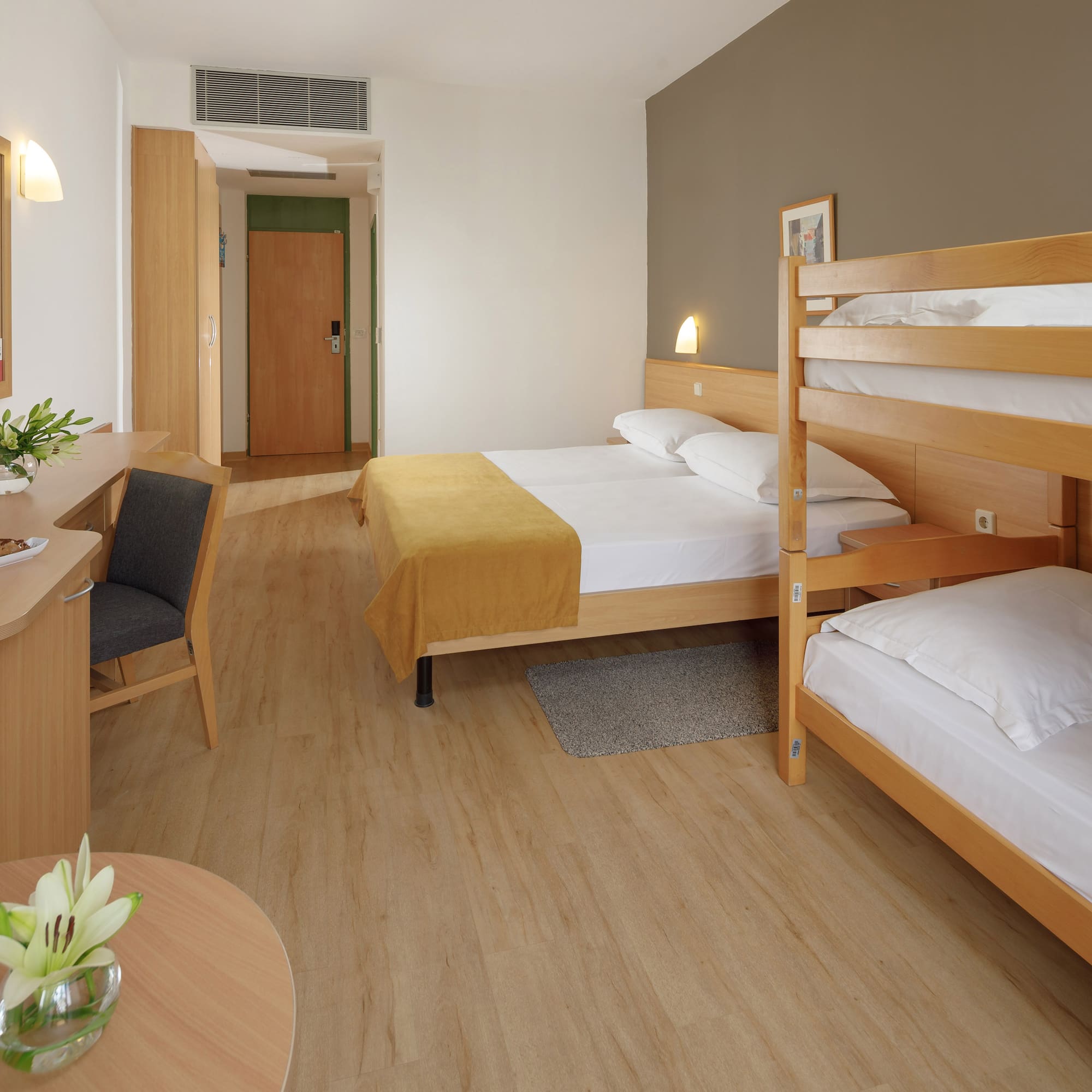 a room with bunk beds and a desk