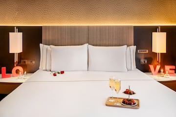 a bed with a tray of champagne and strawberries