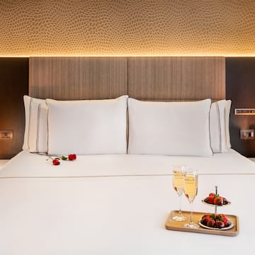 a bed with a tray of champagne and strawberries