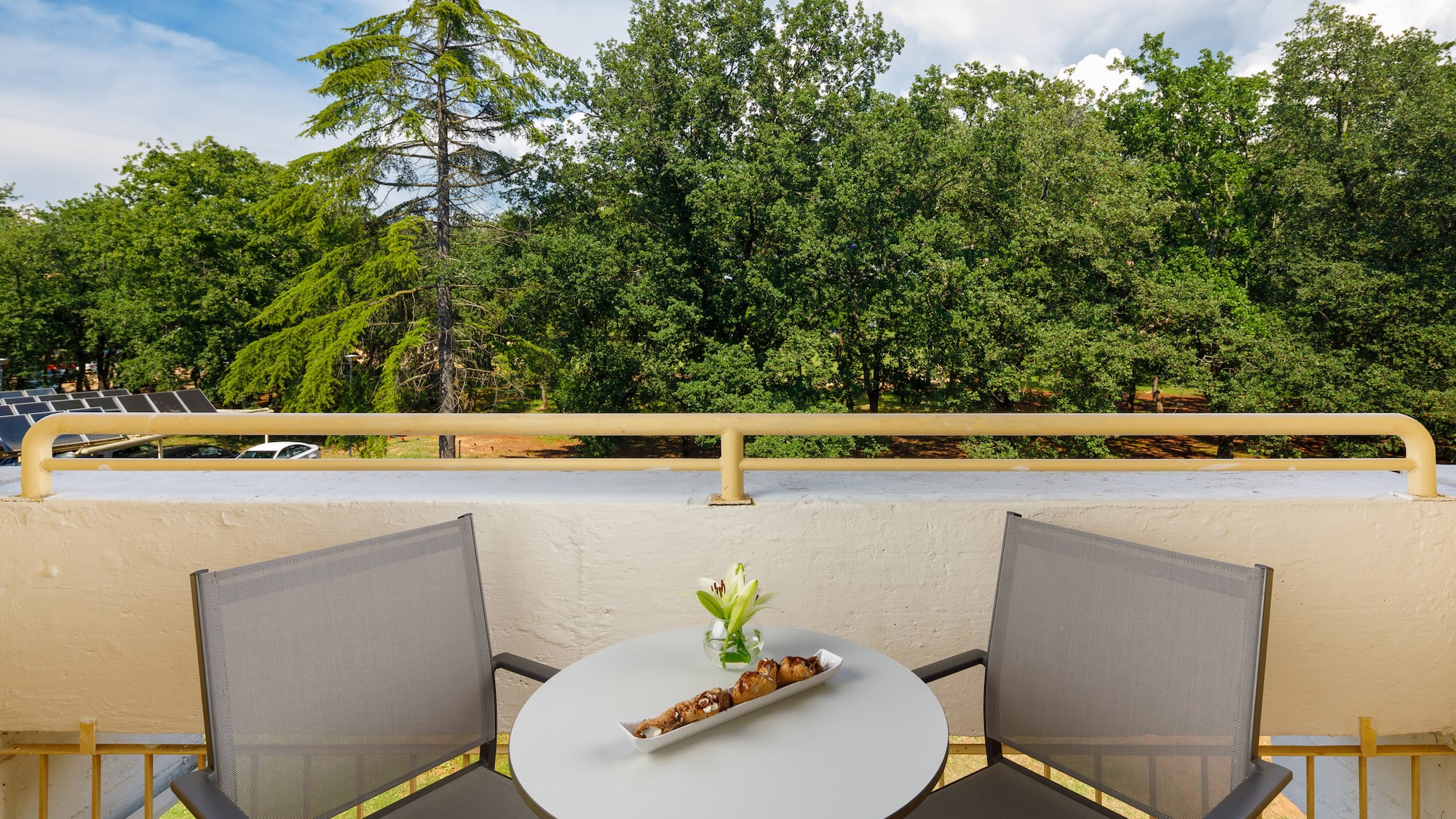 a table with a tray of food on it and chairs on a balcony