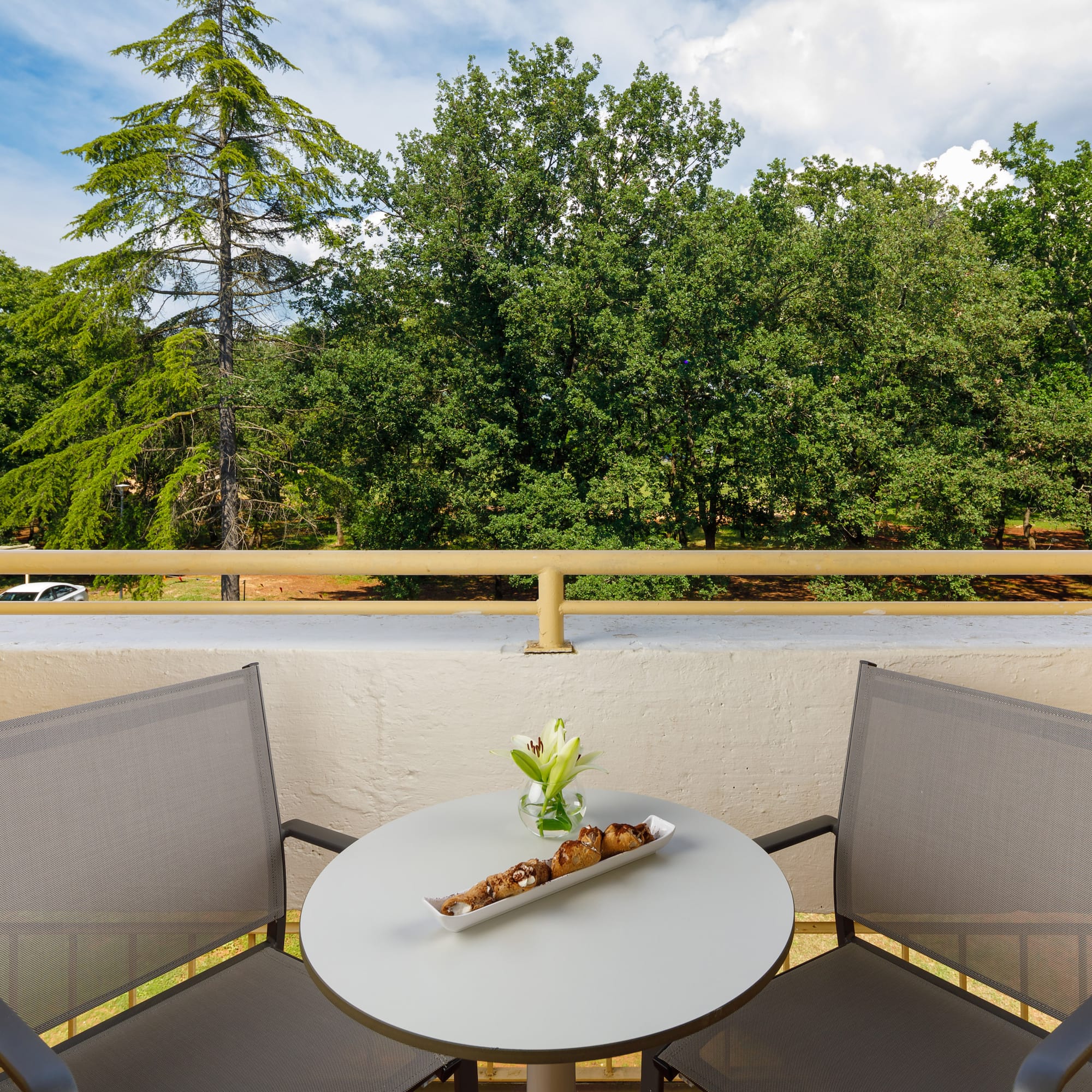 a table with a tray of food on it and chairs on a balcony