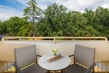 a table with a tray of food on it and chairs on a balcony