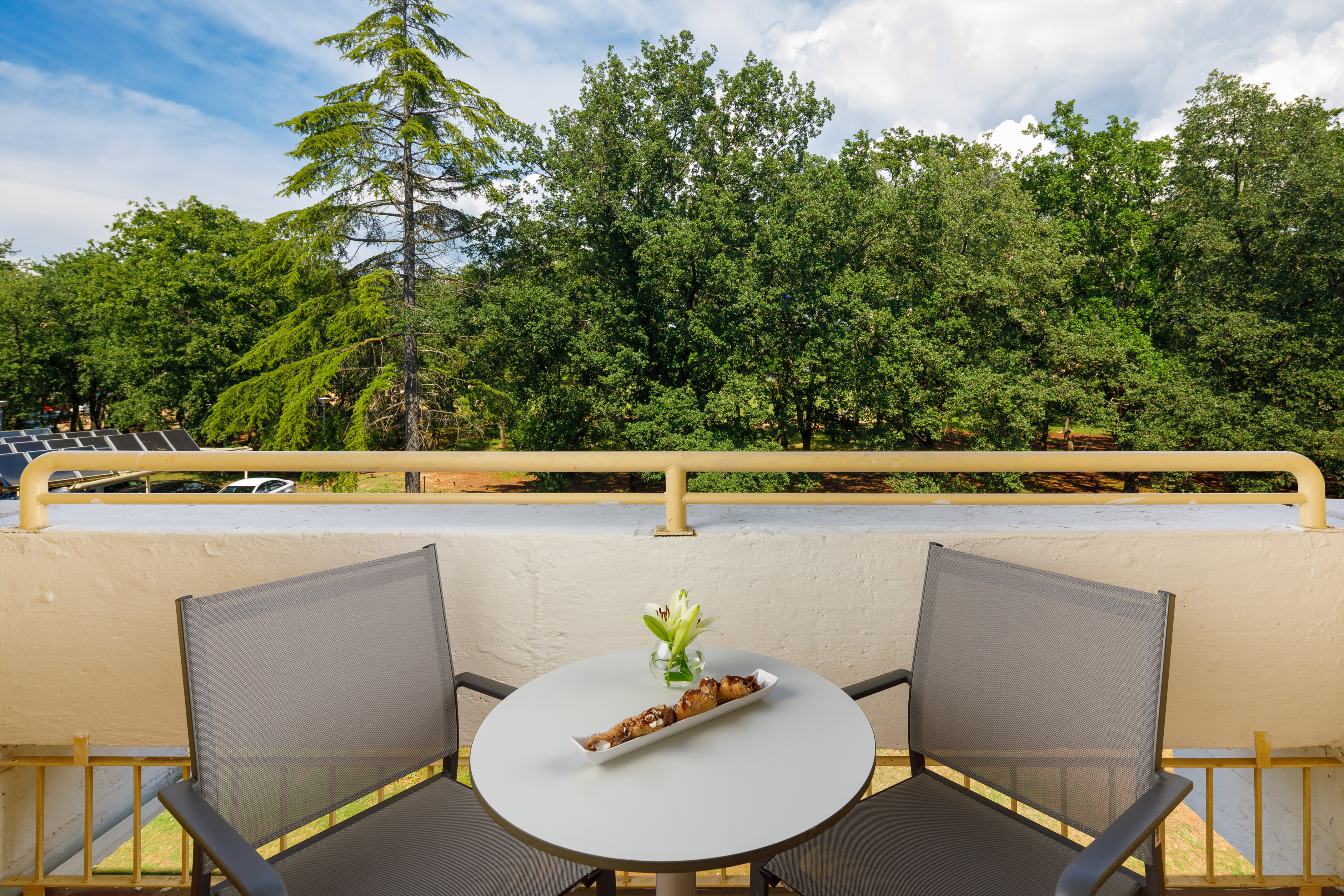 a table with a tray of food on it and chairs on a balcony