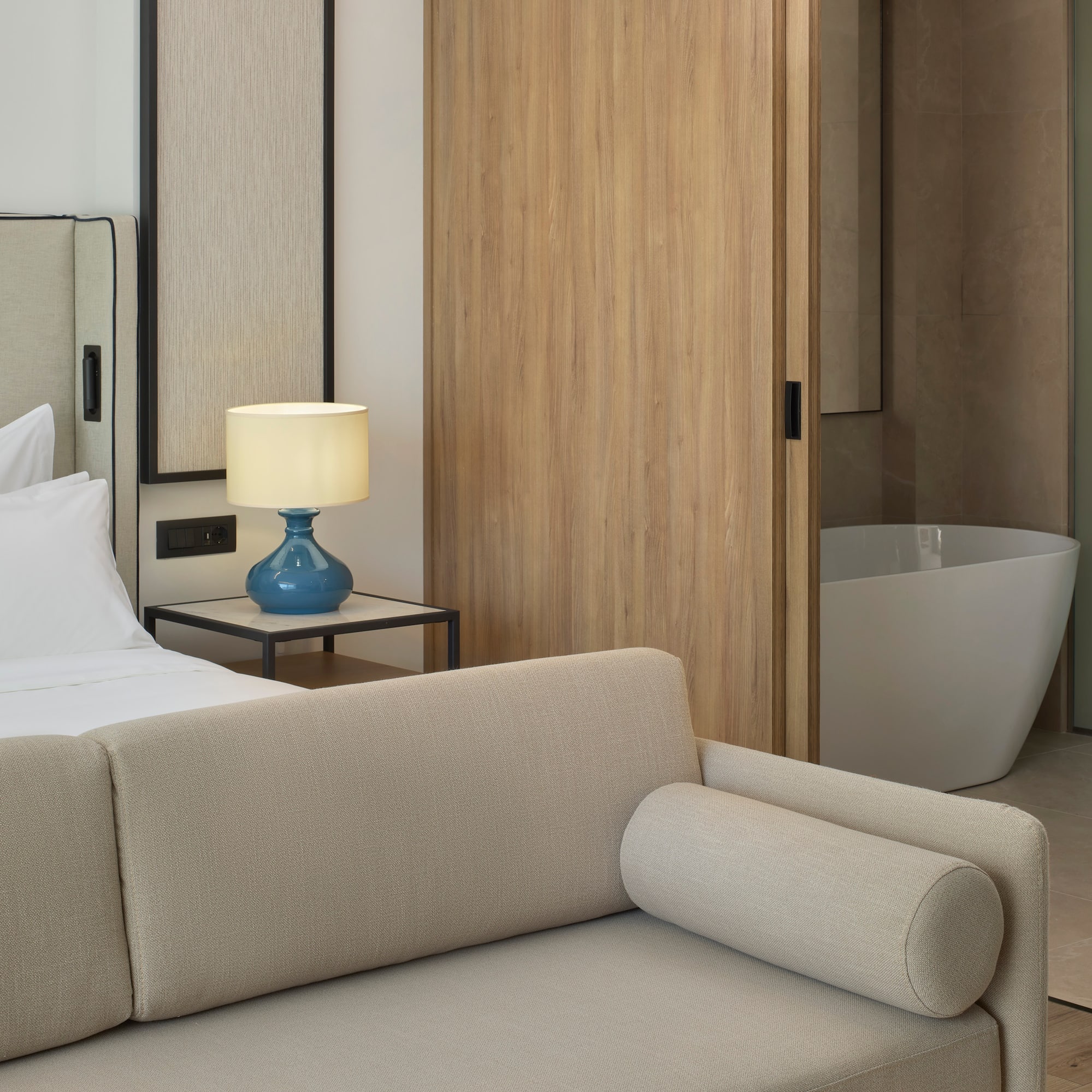 a bedroom with a couch and a bathtub