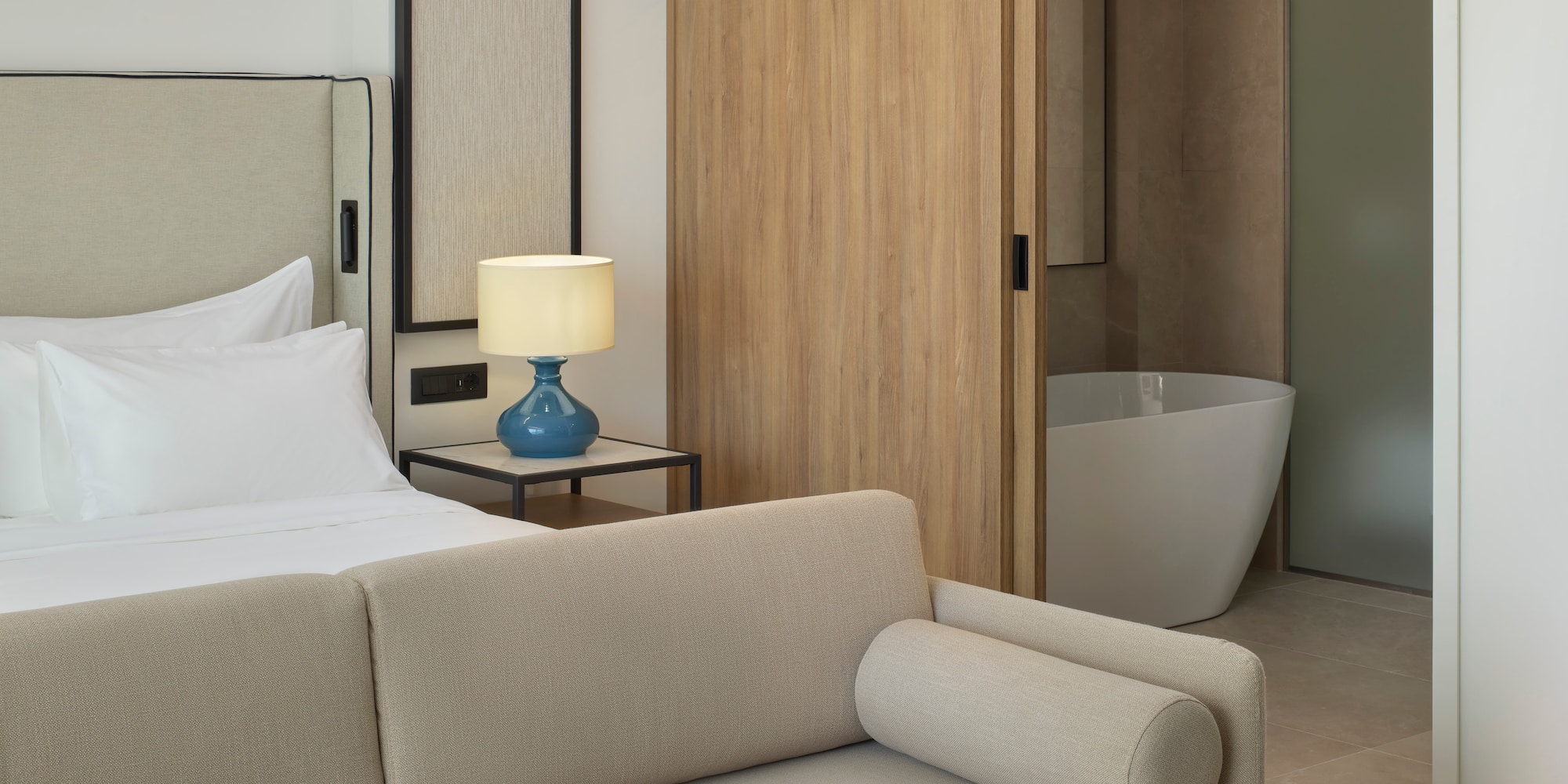 a bedroom with a couch and a bathtub