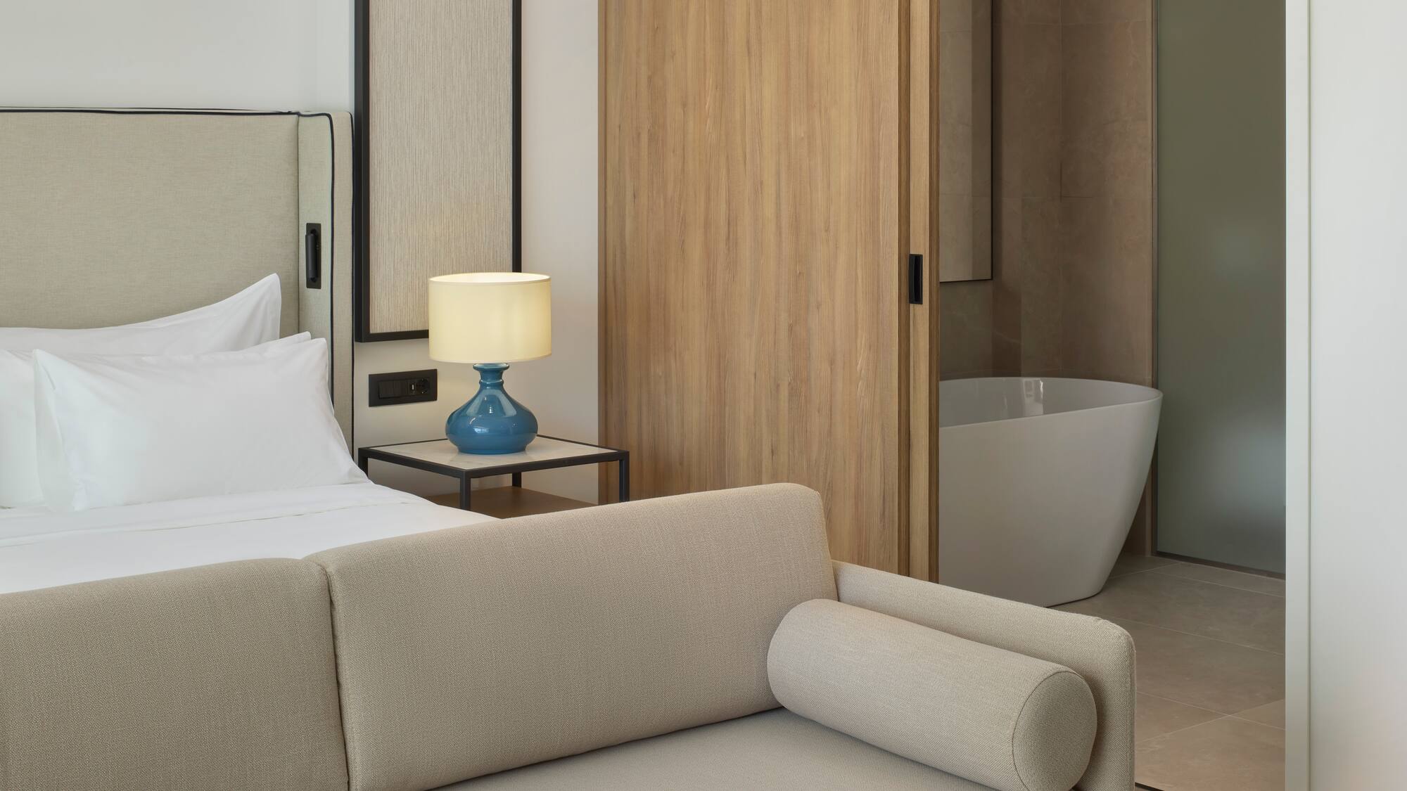 a bedroom with a couch and a bathtub