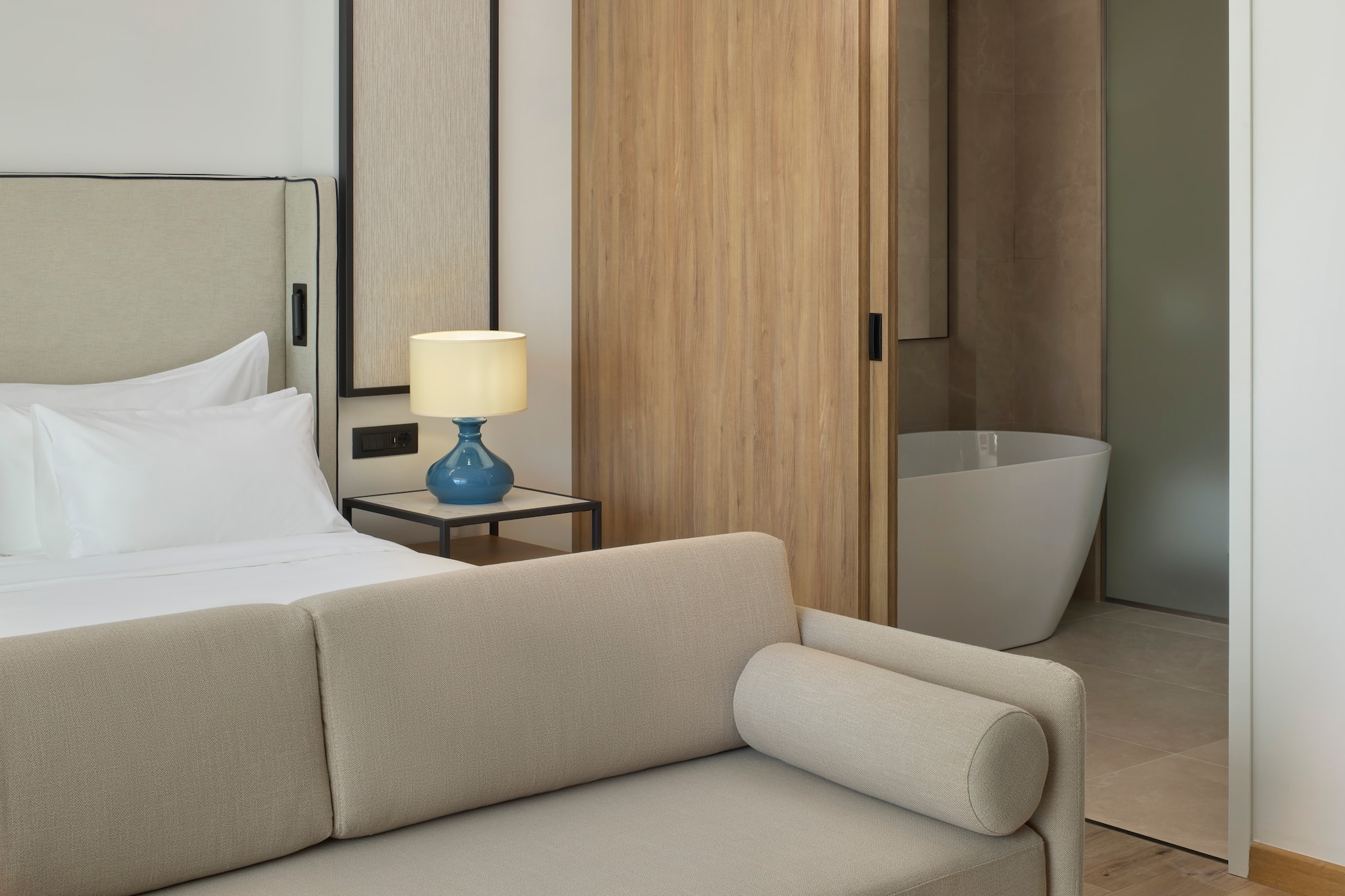 a bedroom with a couch and a bathtub