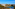 Mallorca beach cove with hotel, turquoise water, pine forests, and rocky cliffs.