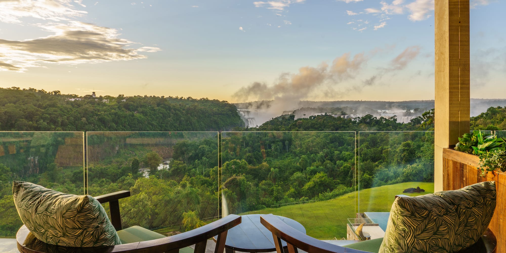 a balcony with a view of a forest and a river