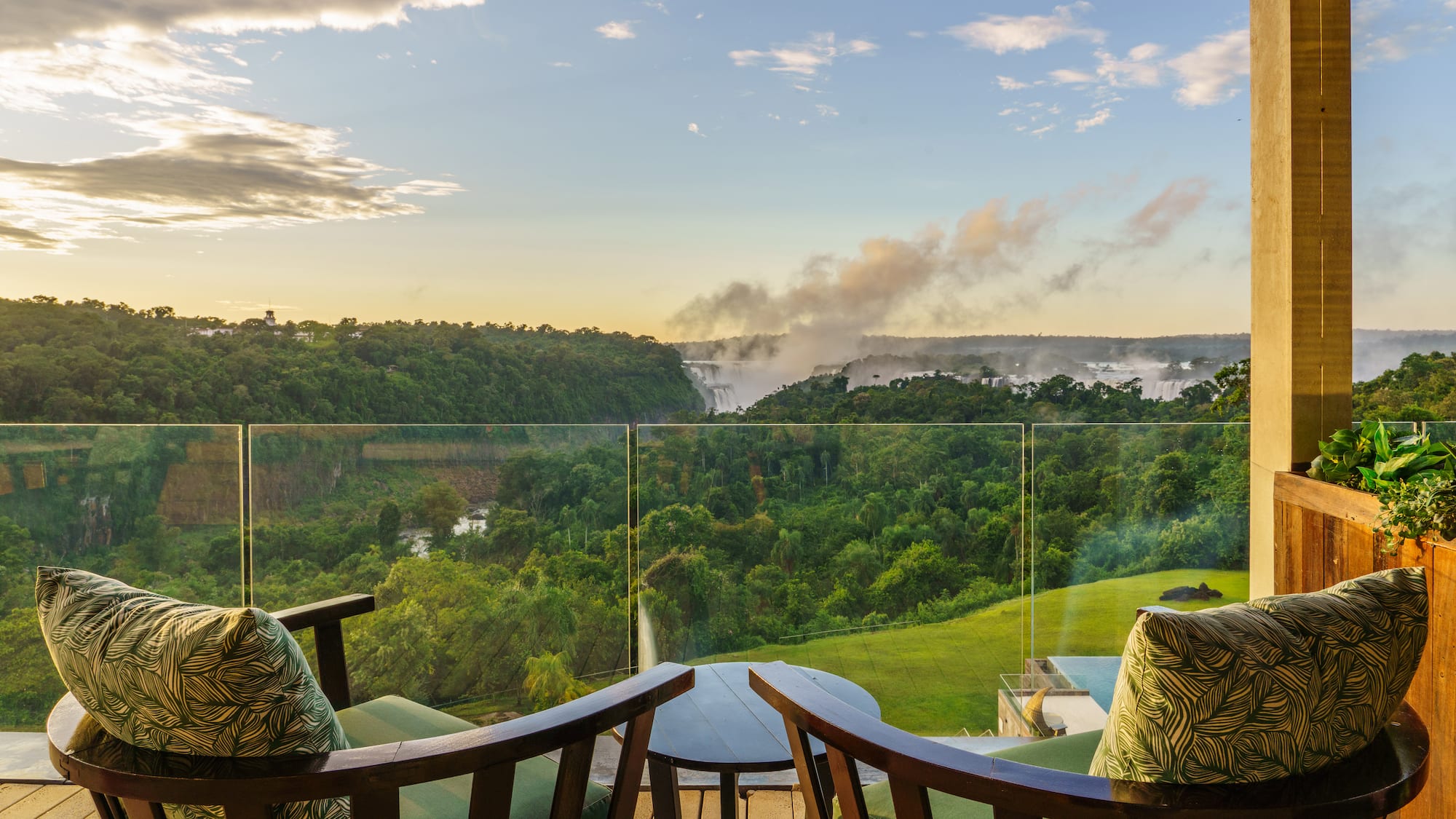 a balcony with a view of a forest and a river
