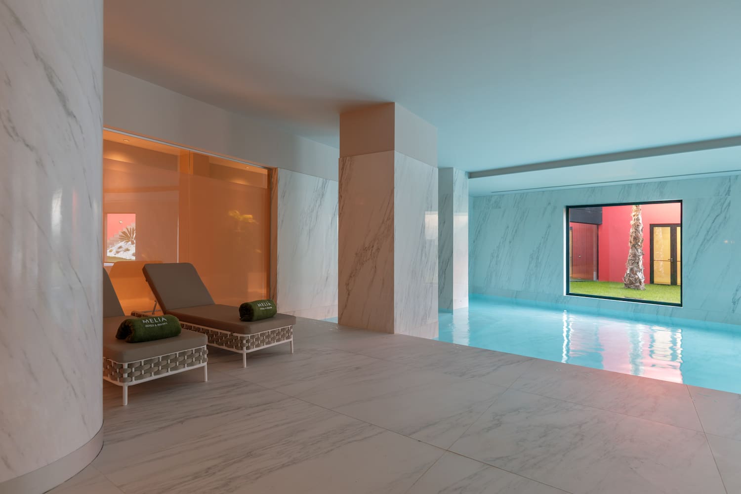 a pool with chairs and a large window