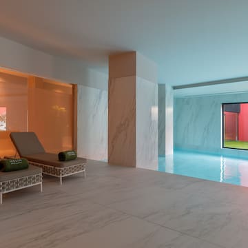 a pool with chairs and a large window