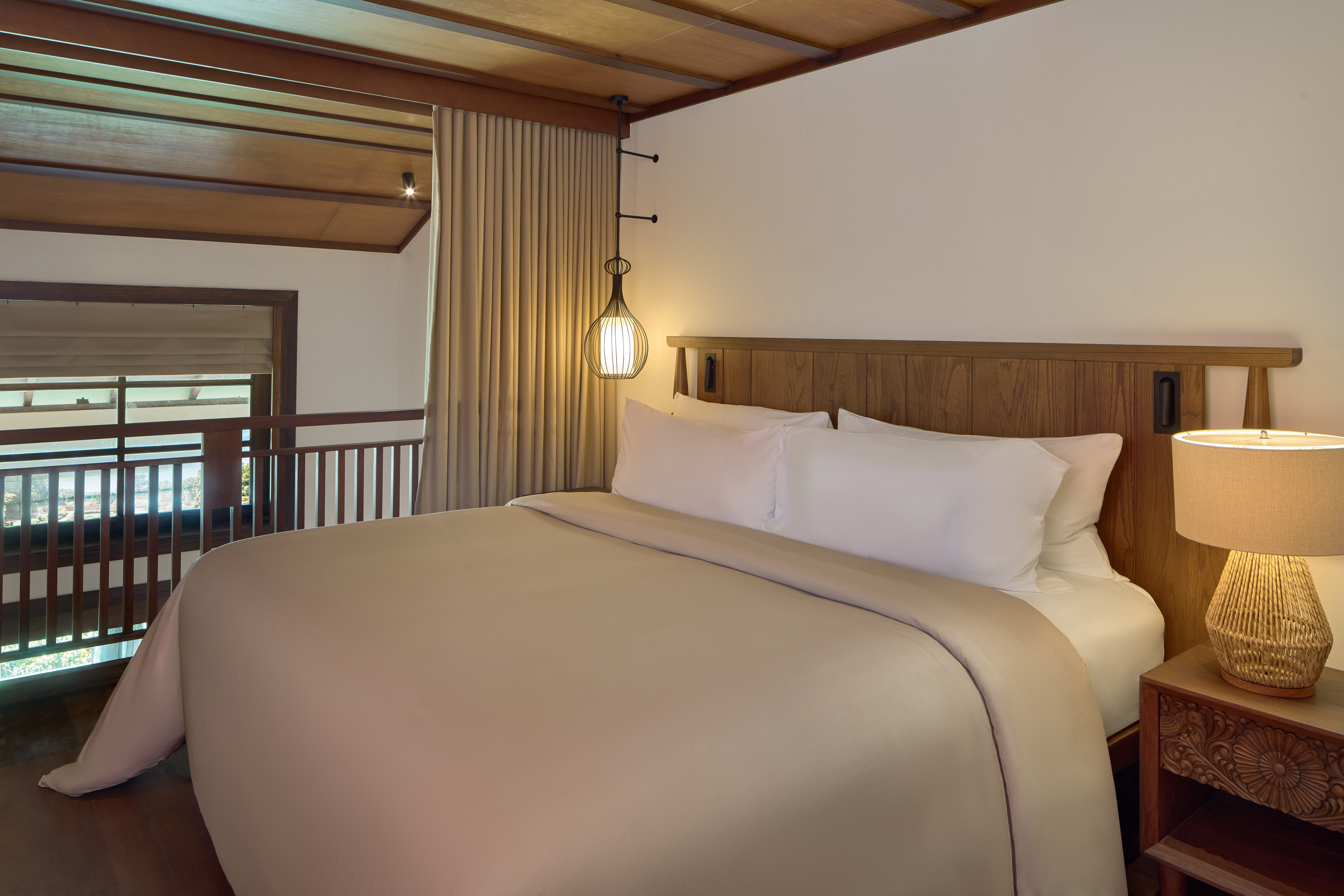 a bed with a wooden headboard and a lamp