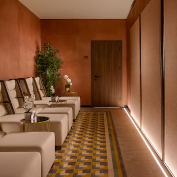 a room with white chairs and a plant