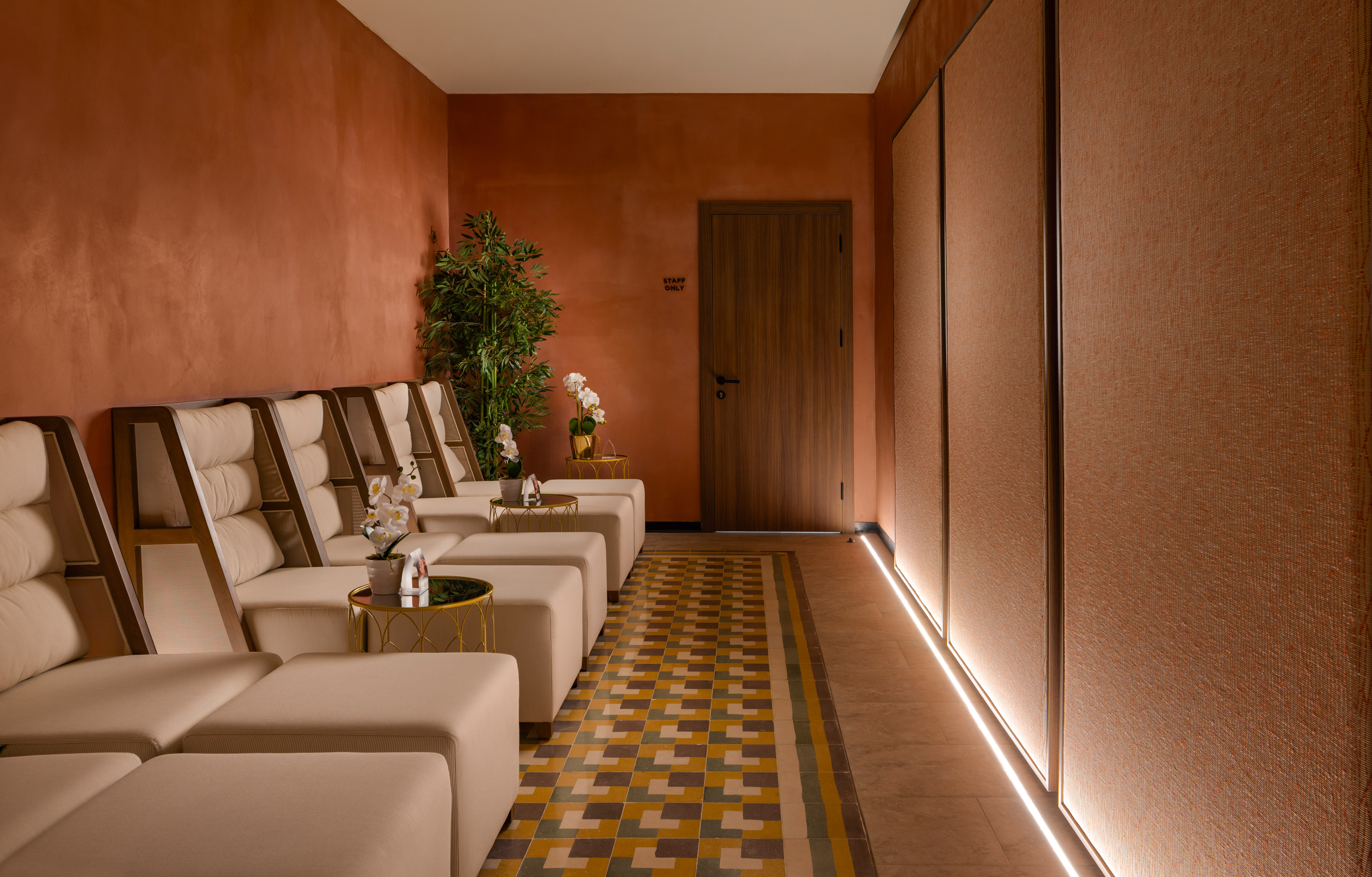 Spa lounge with comfortable recliners, terracotta walls, and modern design.