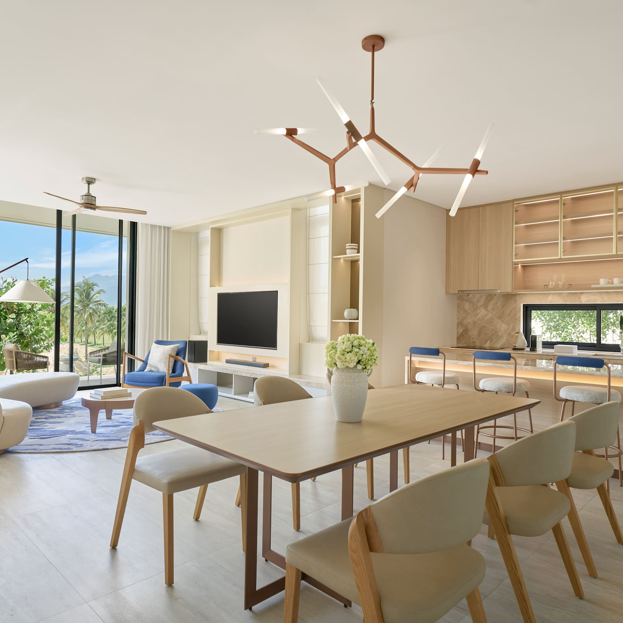 Luxury open-plan living room, dining, and kitchen with tropical views.