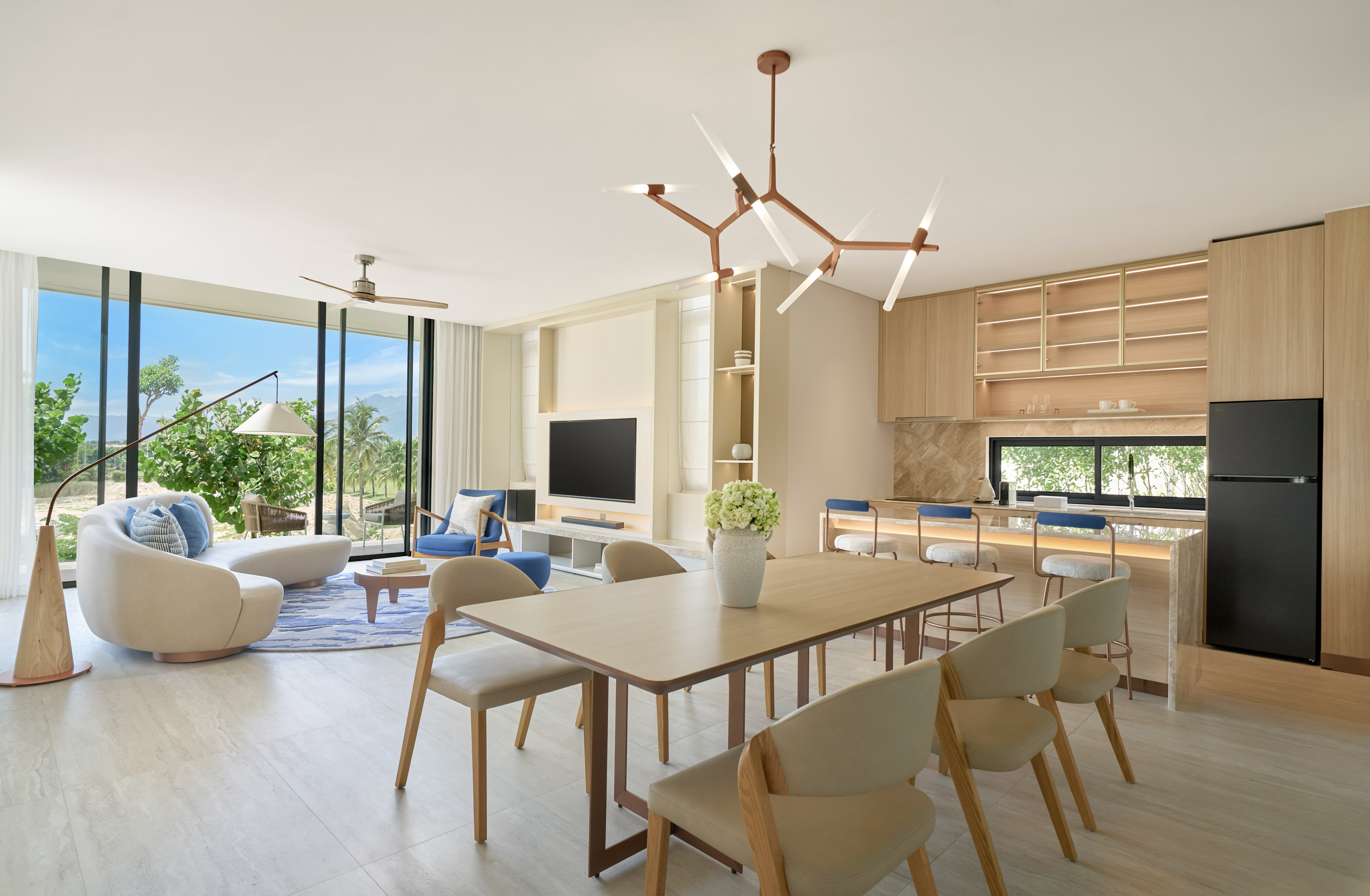 Luxury open-plan living room, dining, and kitchen with tropical views.