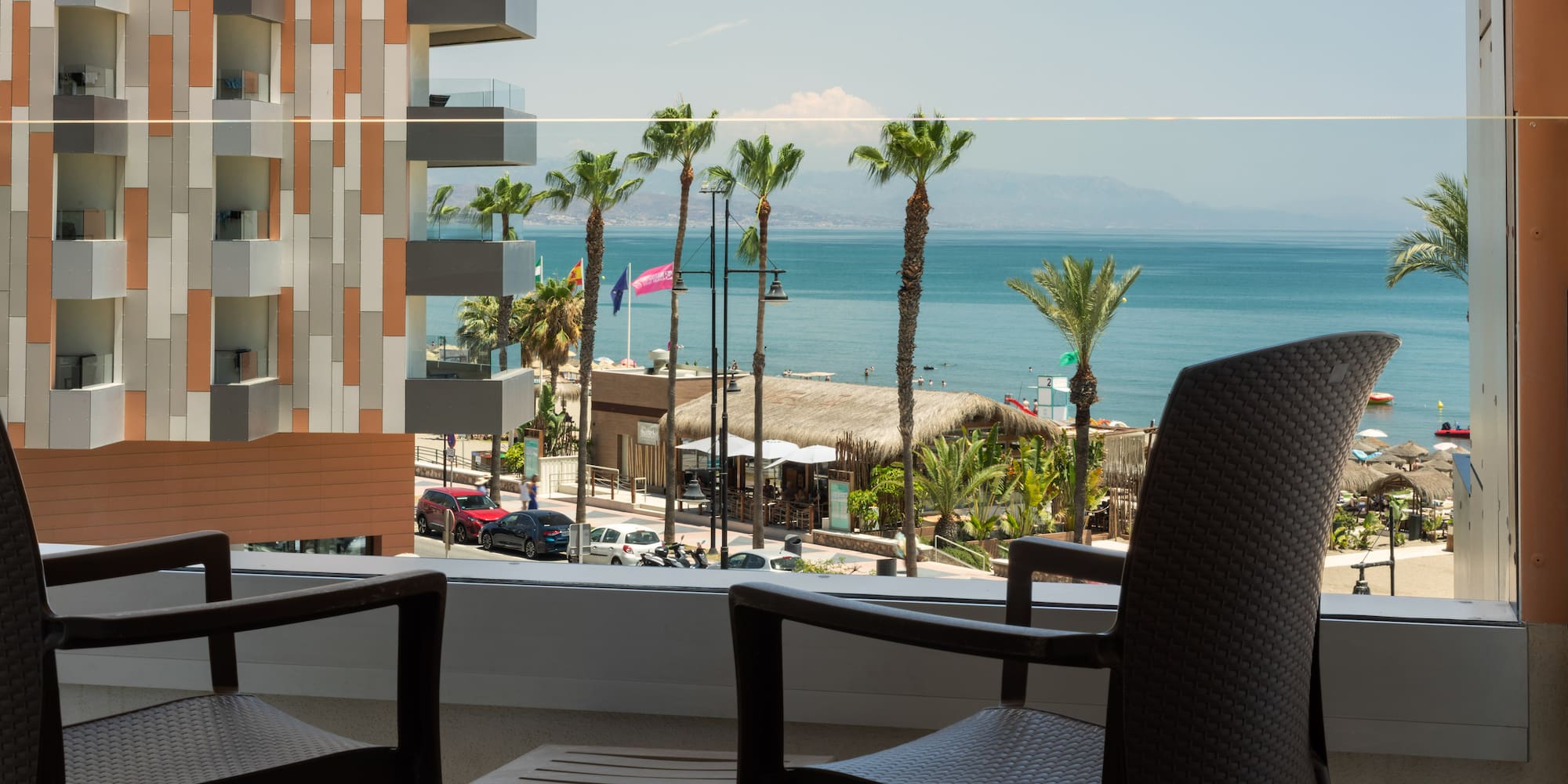 a balcony with chairs and a view of the ocean