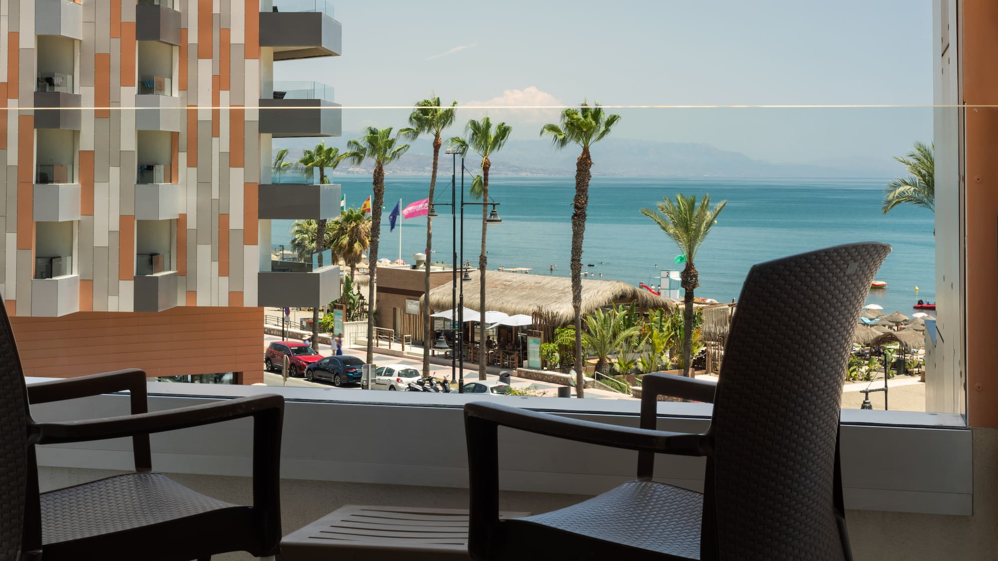 a balcony with chairs and a view of the ocean