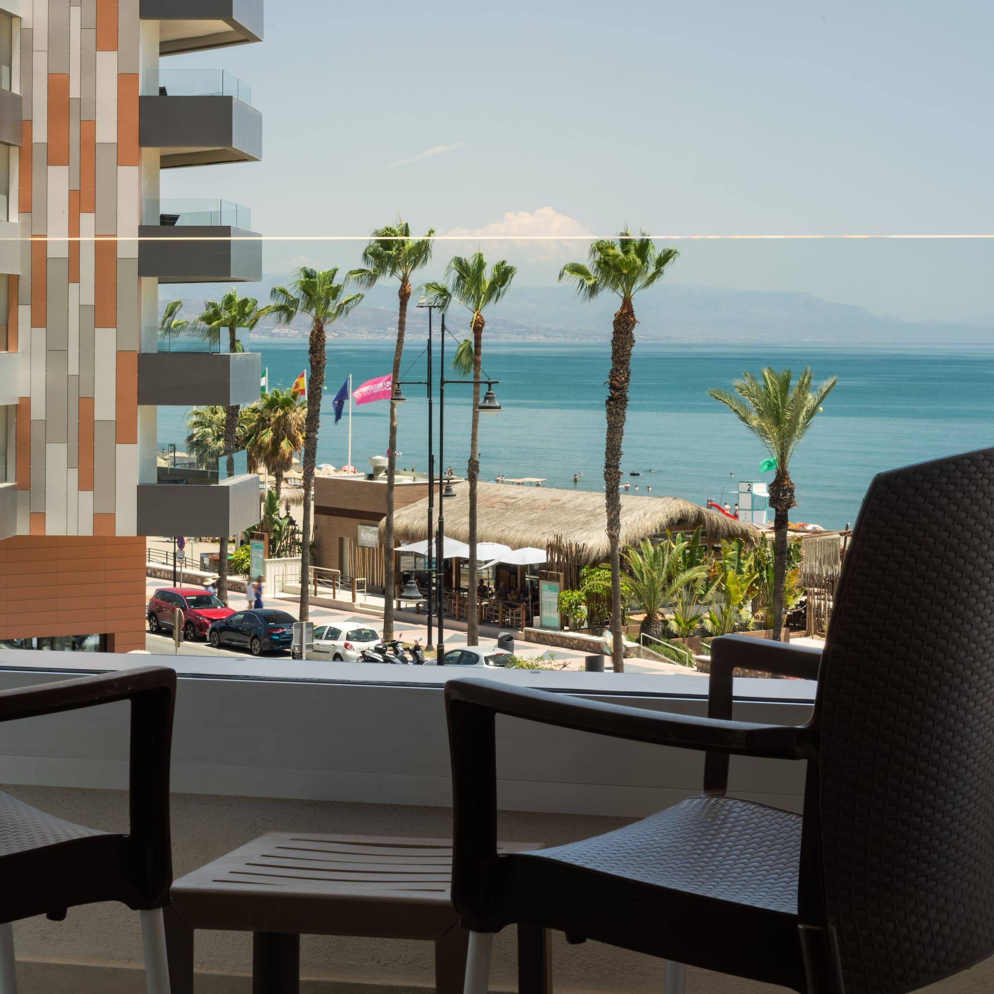a balcony with chairs and a view of the ocean