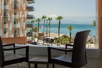 a balcony with chairs and a view of the ocean