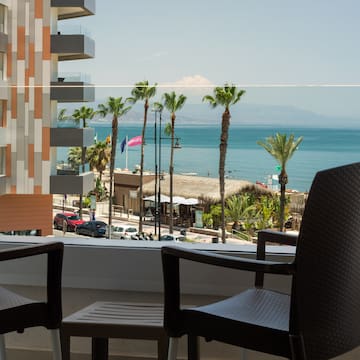 a balcony with chairs and a view of the ocean