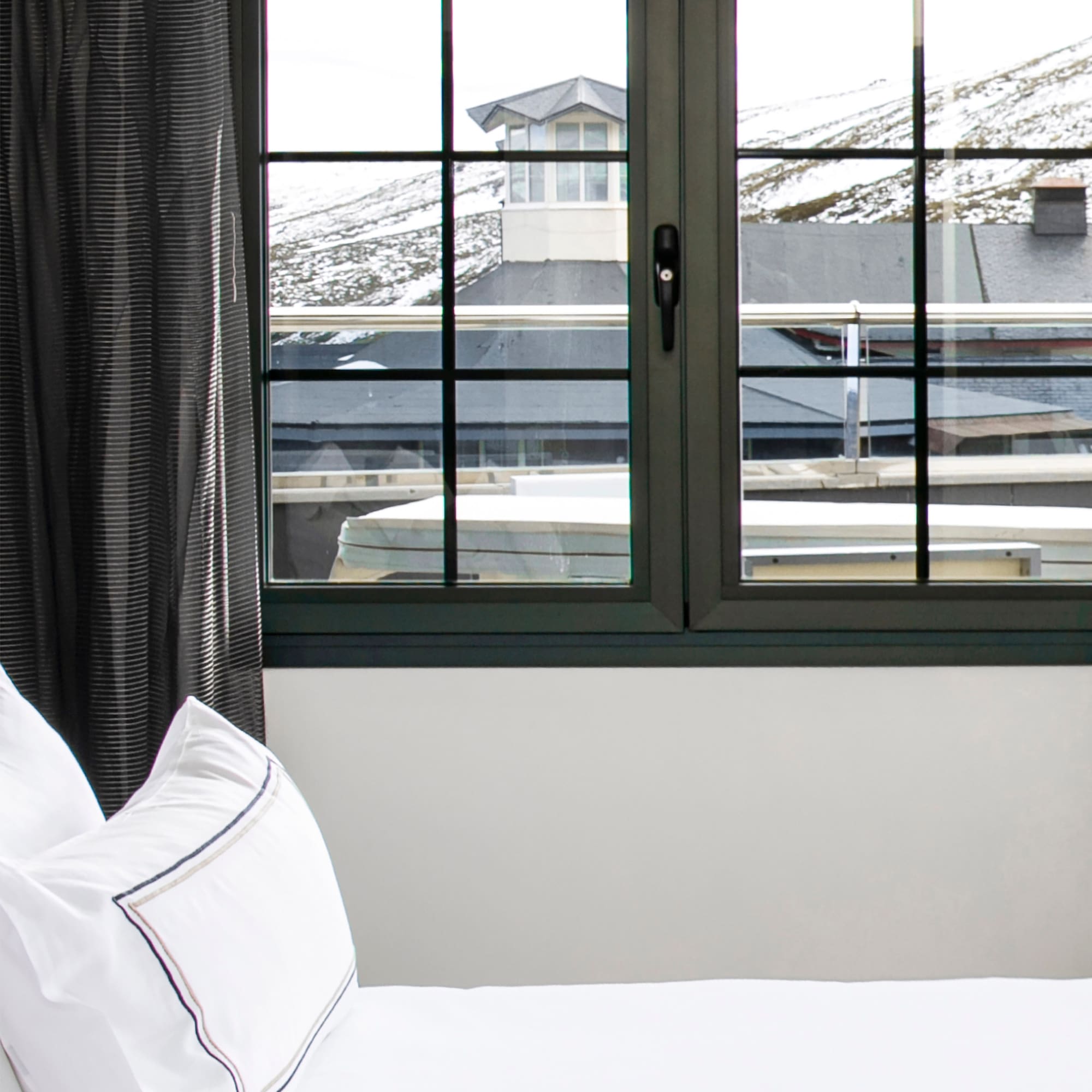 a bed with a window and a view of the mountains