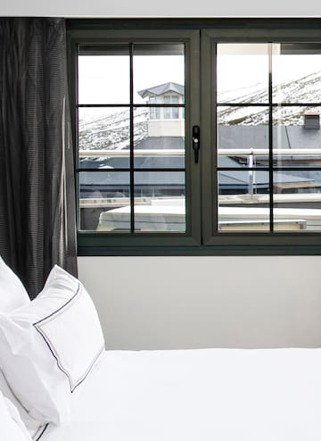 a bed with a window and a view of the mountains