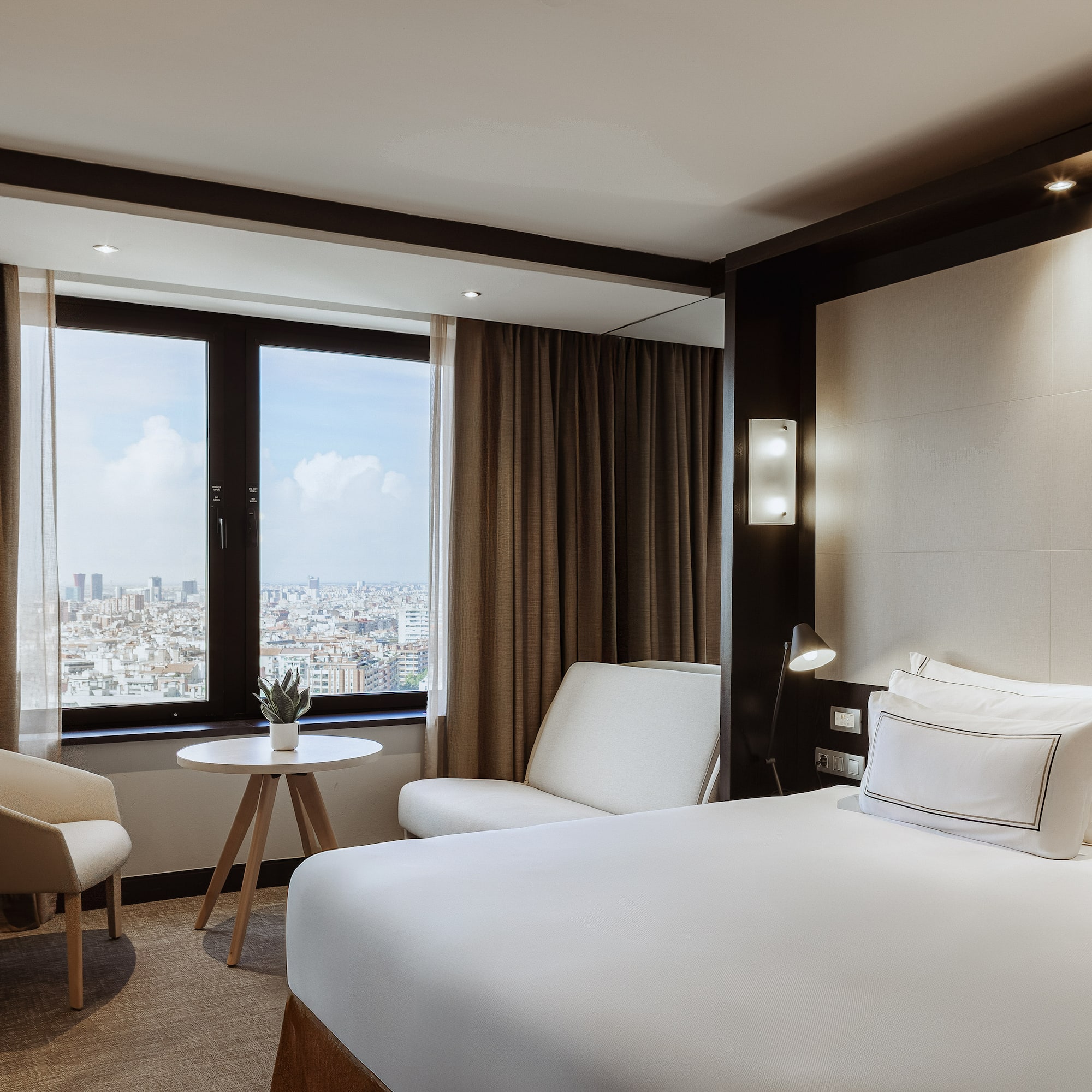 a room with a bed and chairs and a table