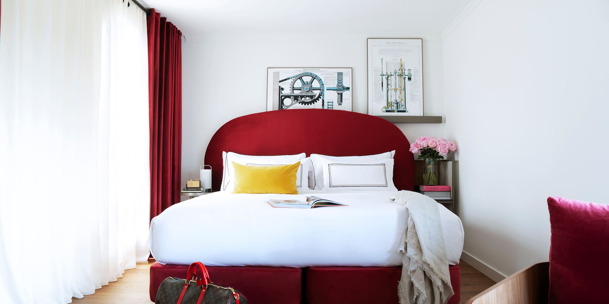 a bed with a red headboard and a bag