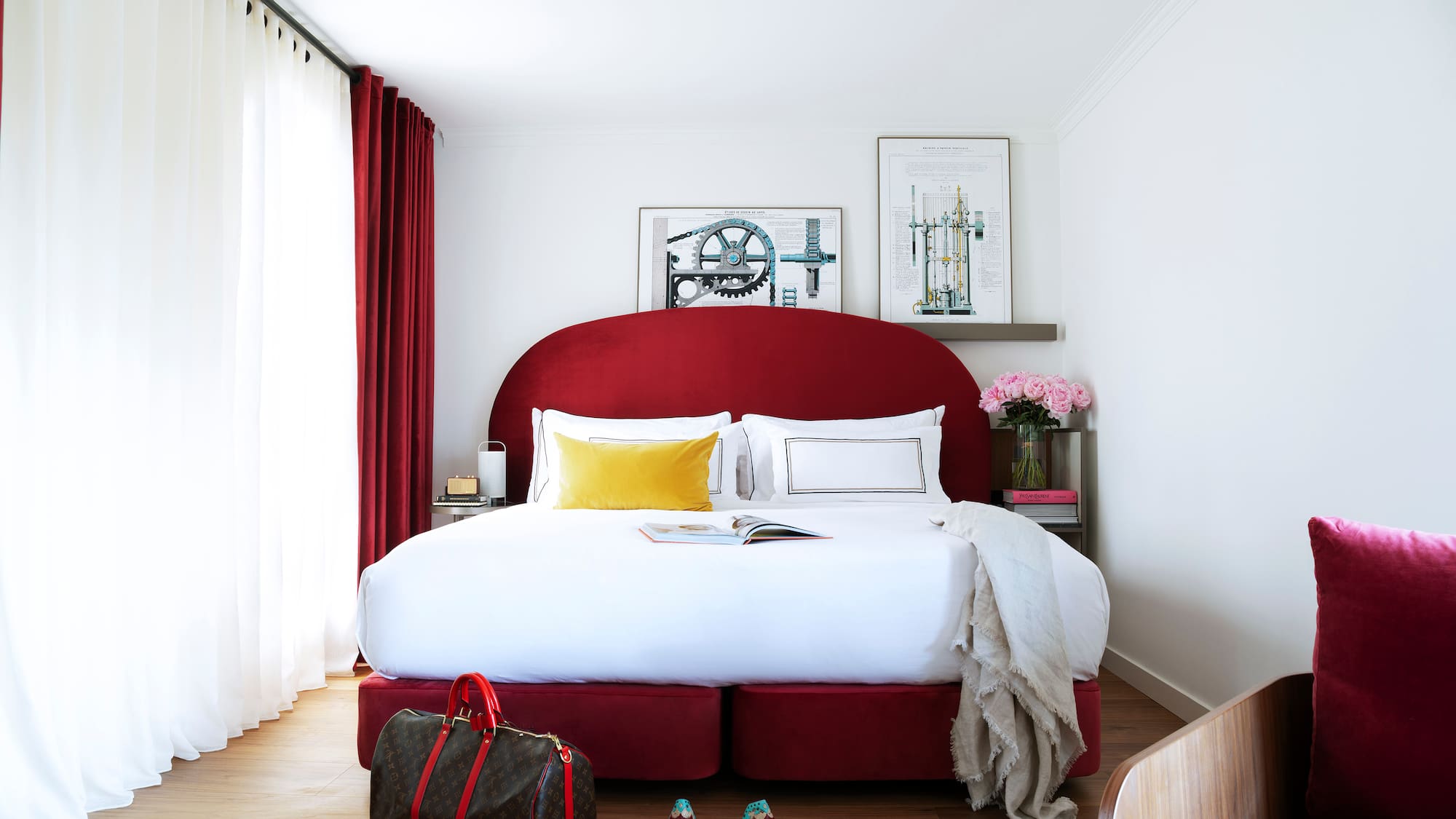 a bed with a red headboard and a bag