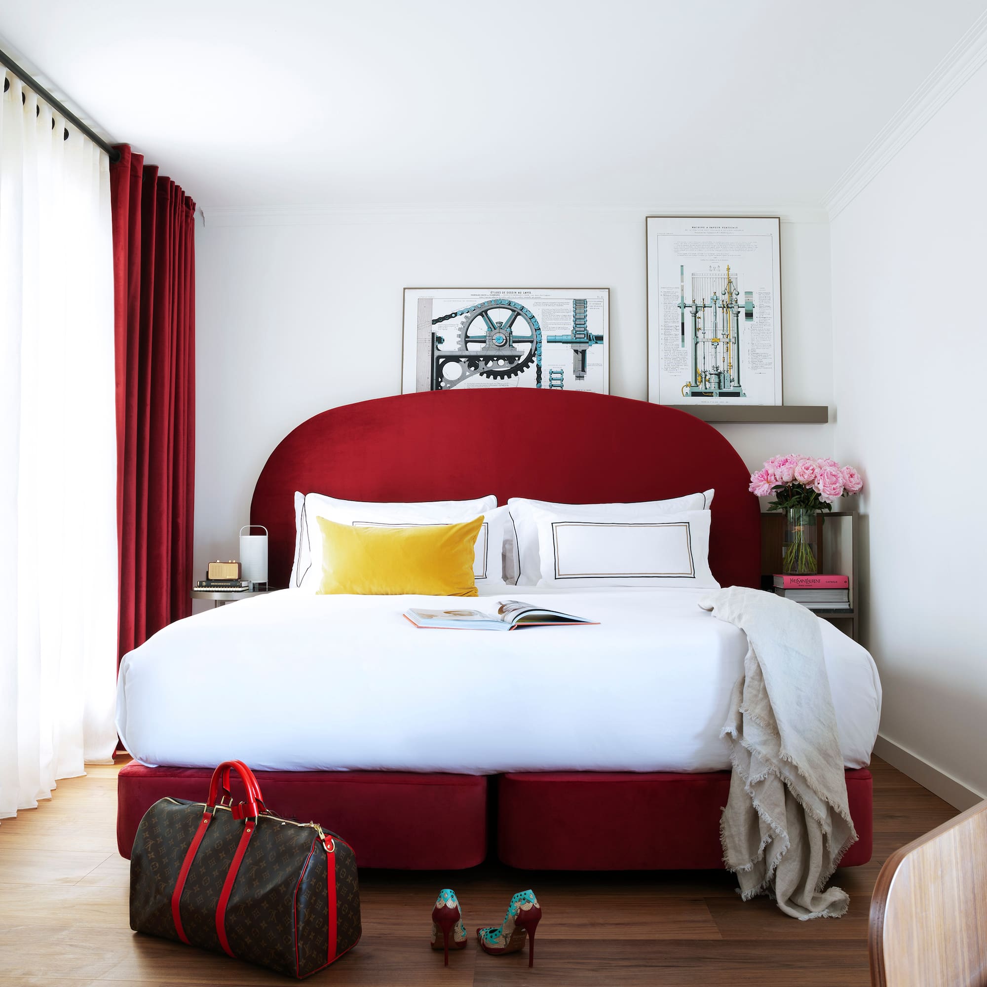 a bed with a red headboard and a bag