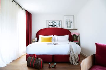 a bed with a red headboard and a bag