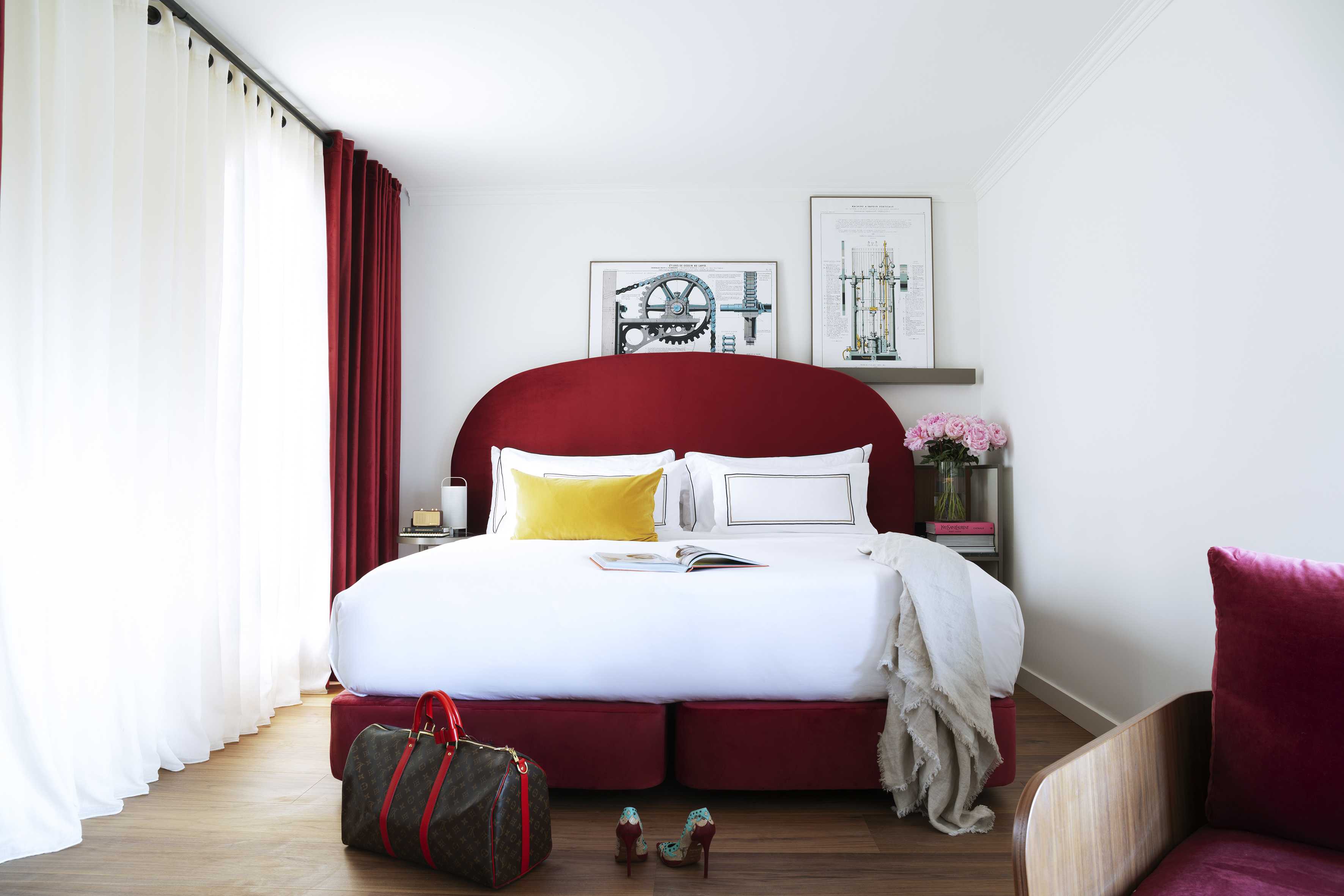 Luxurious red velvet bed, white bedding, modern bedroom, and wood floor.