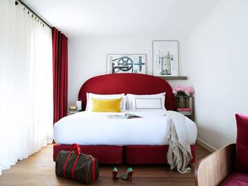 a bed with a red headboard and a bag