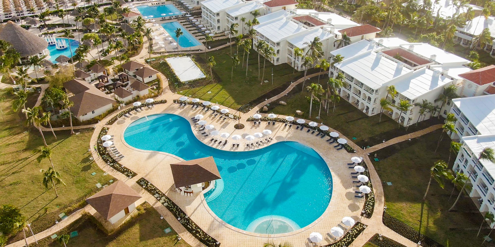 a swimming pool with umbrellas and chairs in a resort