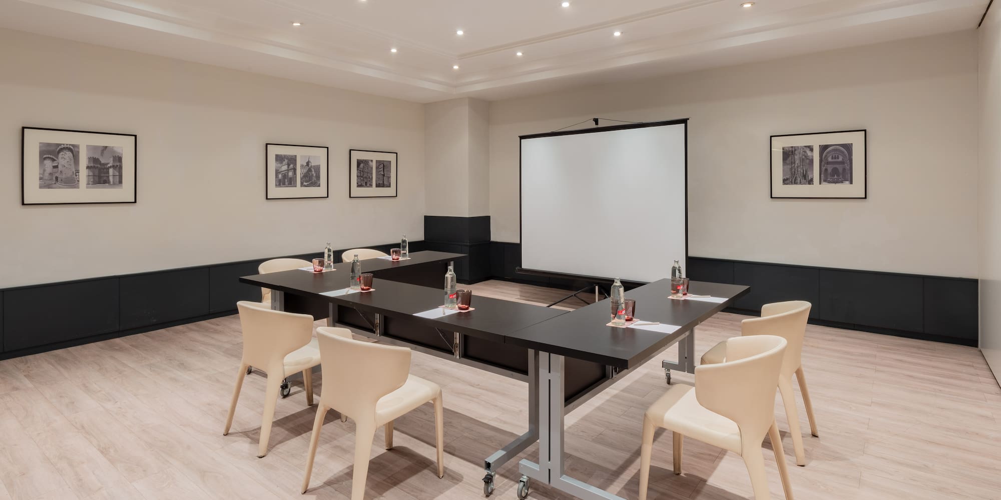 a room with a projection screen and tables