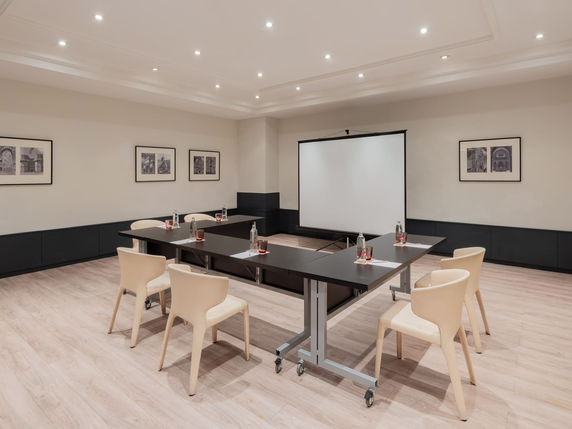 a room with a projection screen and tables