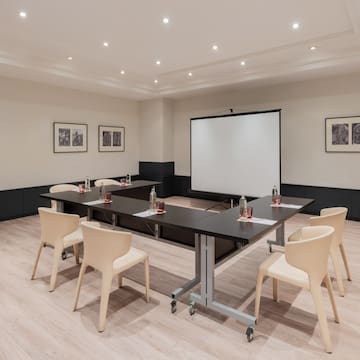 a room with a projection screen and tables
