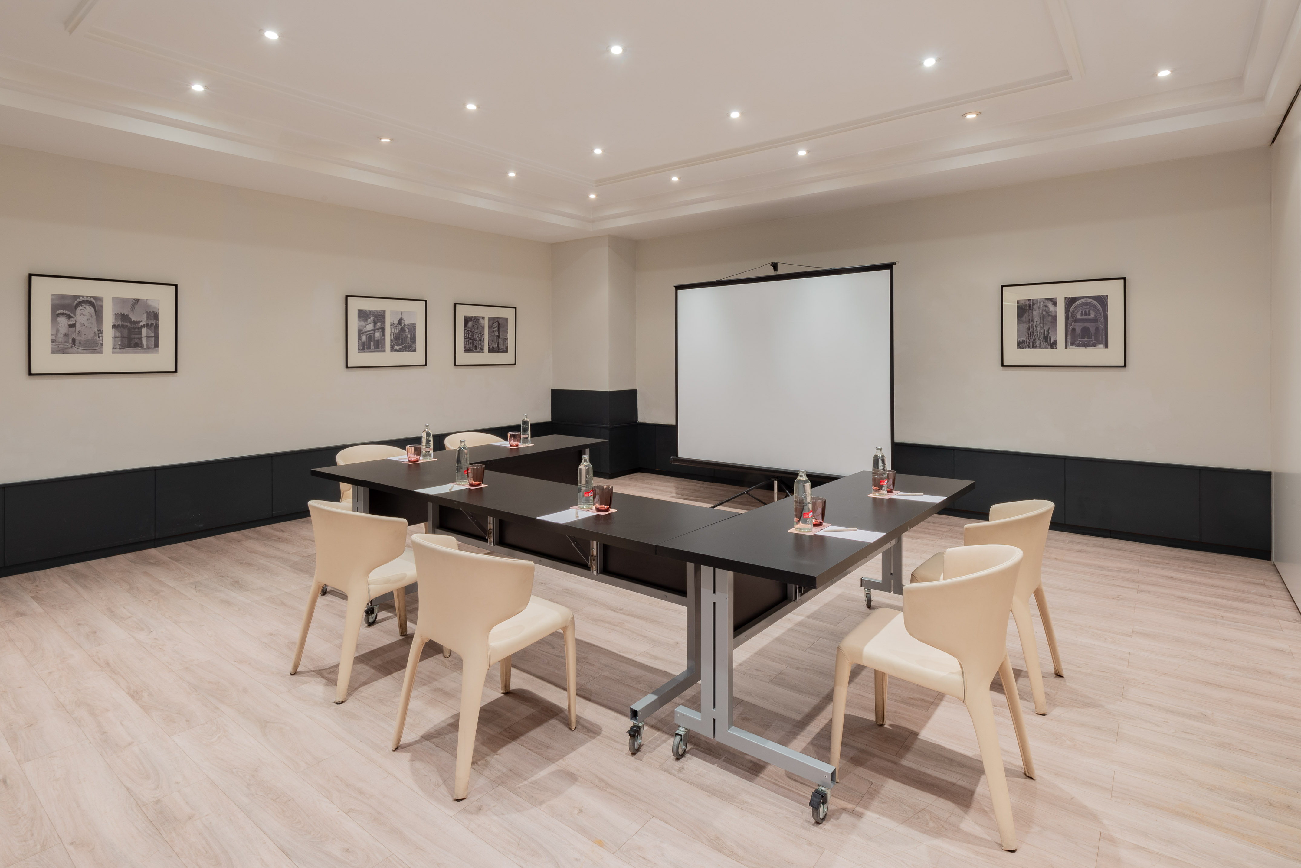 a room with a projection screen and tables