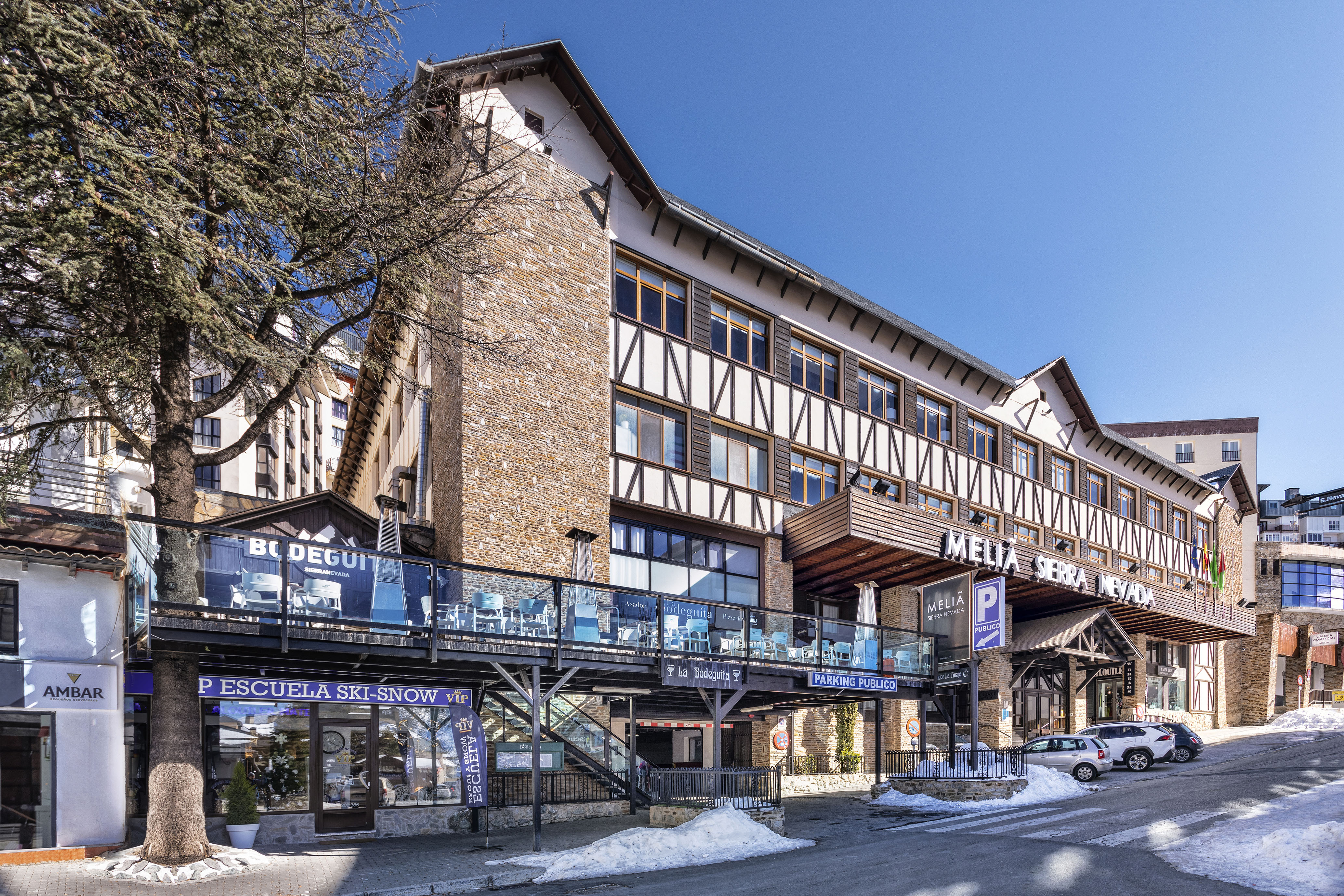 Melia Sierra Nevada ski hotel, alpine style, with terraces and snow.