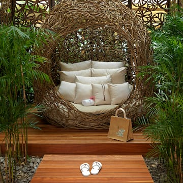 a chair with pillows and sandals in front of a wood deck