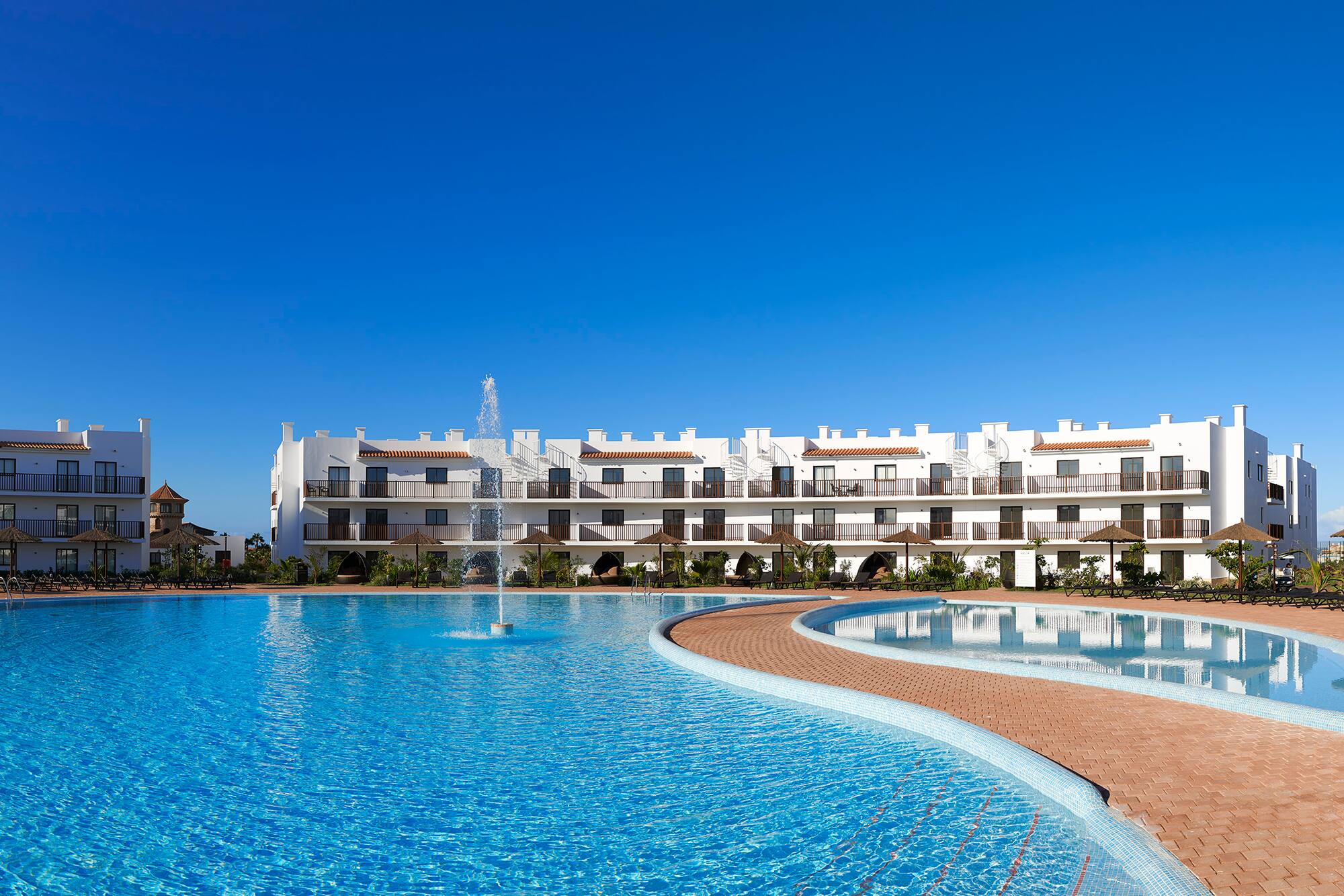 a pool with a fountain in front of a building