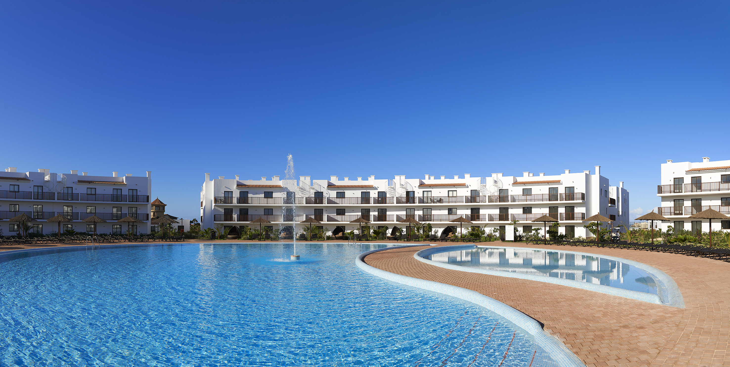 a pool with a fountain in front of a building