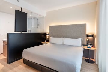 a bed with a black headboard and a black wall