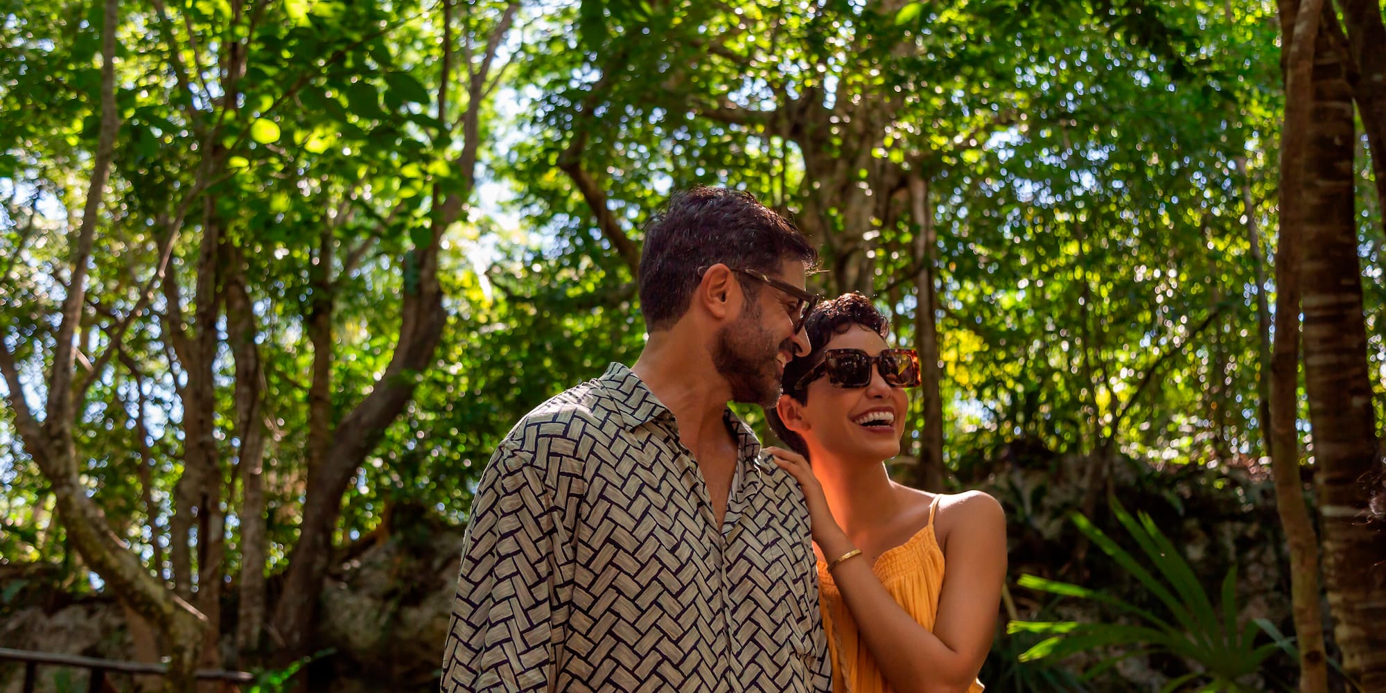 a man and woman standing in the woods