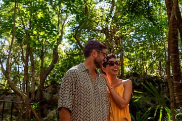 a man and woman standing in the woods